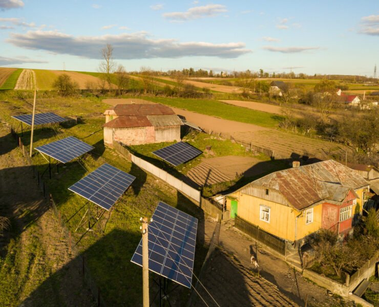 Aerial top down view of solar panels in green rural village yard.